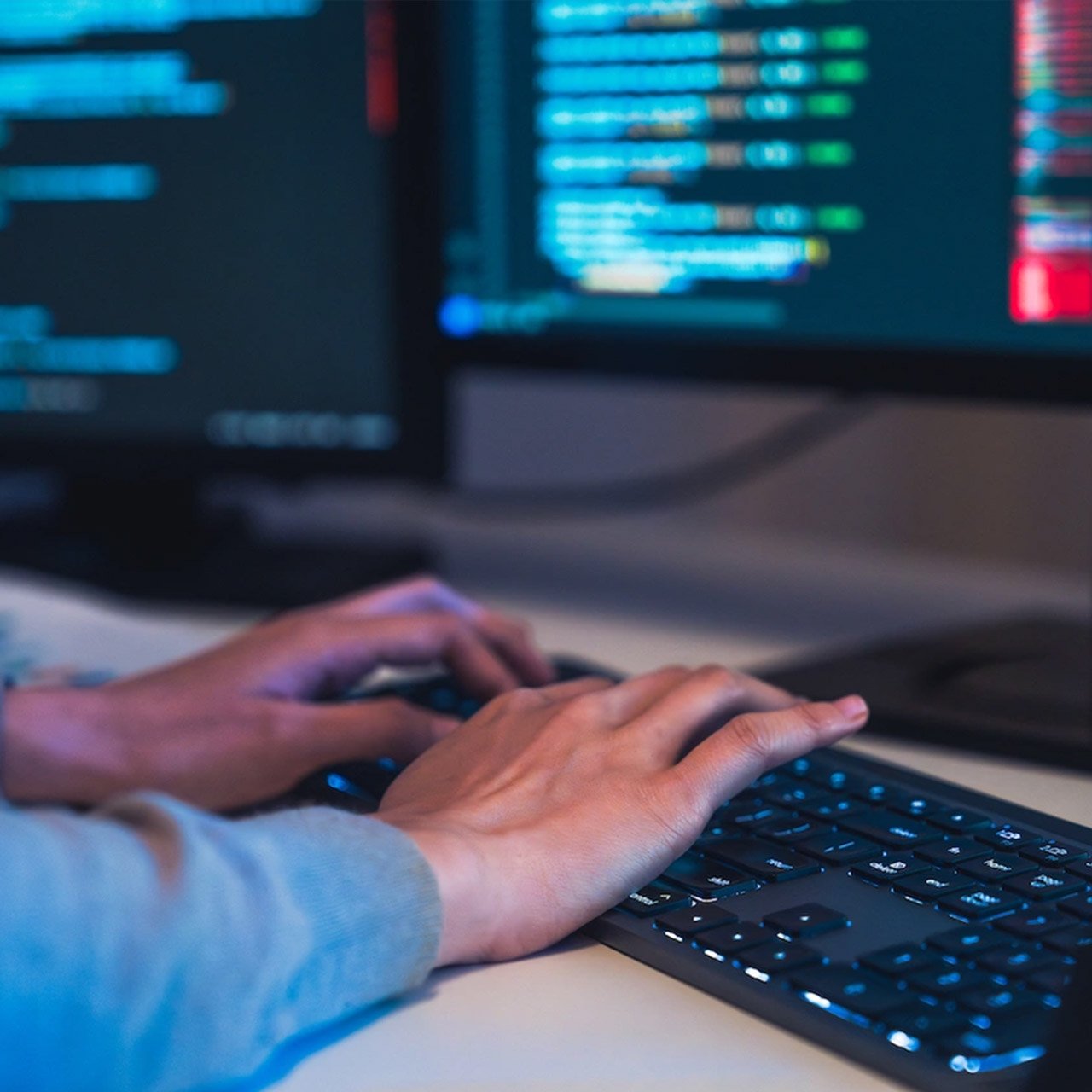 Finger tippen auf Tastatur vor Computerbildschirmen Finger tippen auf Tastatur vor Computerbildschirmen